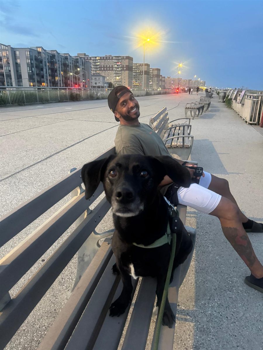 Jamal and his dog on the Rockaway boardwalk at dusk